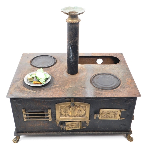 181 - A 19th century German Bavarian tin and brass plate table top children's stove. The stove having thre... 