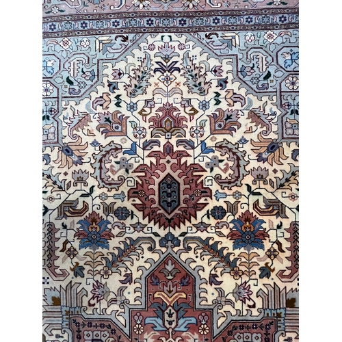 264 - A Persian Heriz hand woven wool floor carpet rug. The carpet having a central pink medallion of geom... 