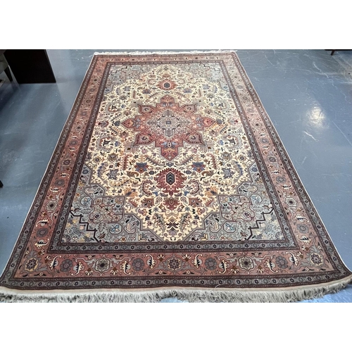 264 - A Persian Heriz hand woven wool floor carpet rug. The carpet having a central pink medallion of geom... 