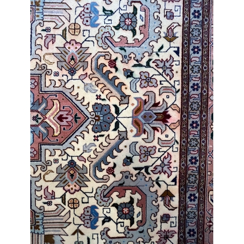 264 - A Persian Heriz hand woven wool floor carpet rug. The carpet having a central pink medallion of geom... 