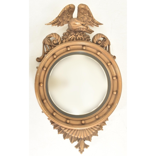 293 - A 19th century Regency style gilt wood & gesso worked convex eagle wall hanging mirror. The mirr... 