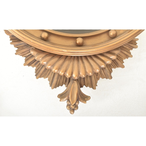 293 - A 19th century Regency style gilt wood & gesso worked convex eagle wall hanging mirror. The mirr... 