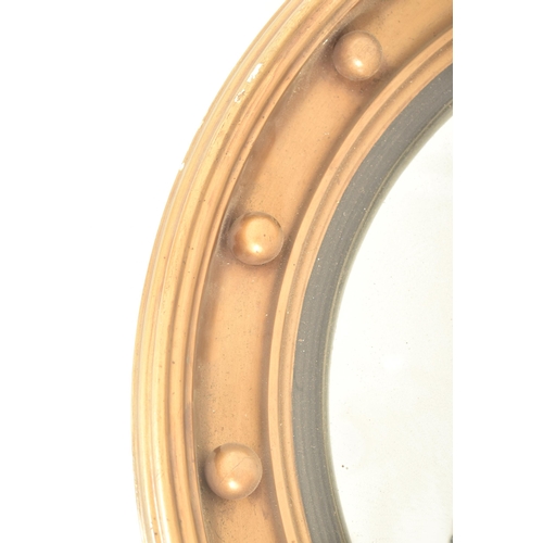 293 - A 19th century Regency style gilt wood & gesso worked convex eagle wall hanging mirror. The mirr... 