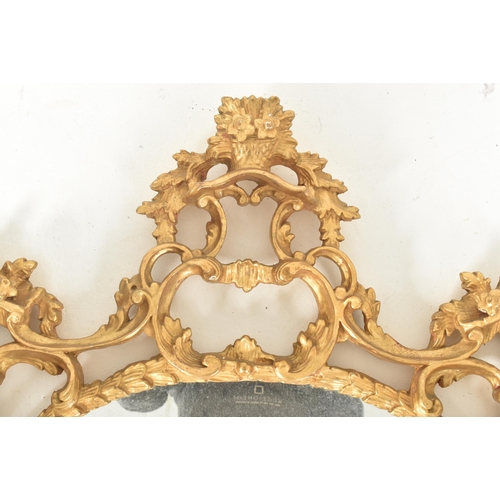 302 - A Rococo inspired French 19th century carved giltwood wall hanging mirror. The mirror having an intr... 