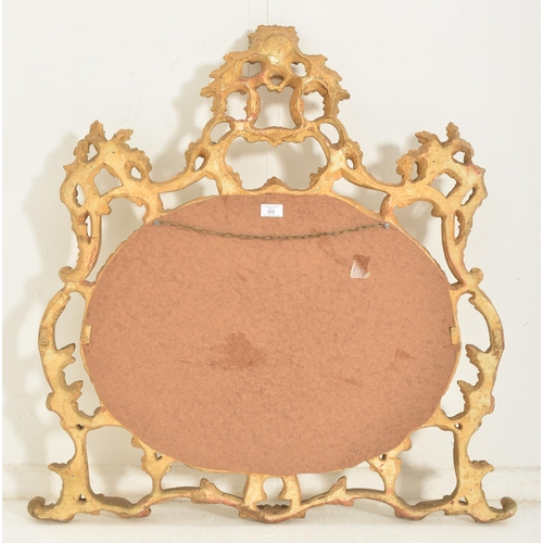 302 - A Rococo inspired French 19th century carved giltwood wall hanging mirror. The mirror having an intr... 