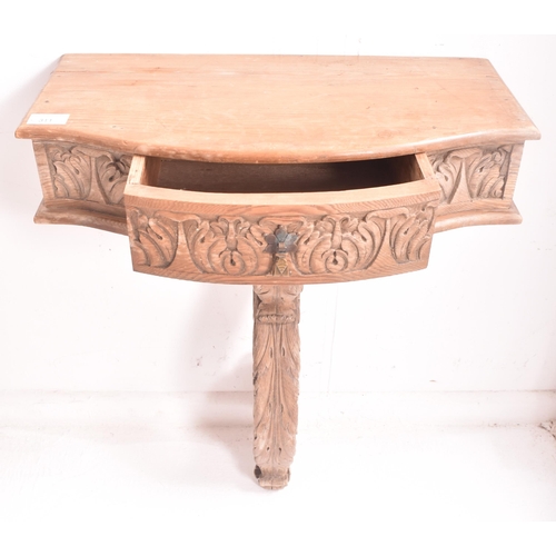 311 - A pair of continental Rococo inspired carved stripped wood wall console hall tables. Each monopedic ... 