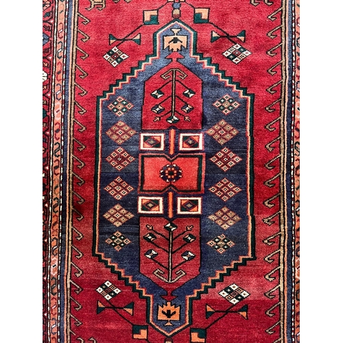 318 - A 20th century Persian Islamic Bakhtiari floor carpet rug. The carpet having a central geometric med... 