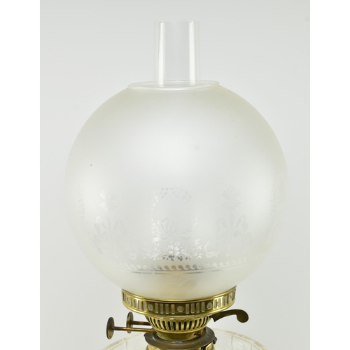 322 - A Victorian 19th century gilt metal & glass reservoir oil lamp / light. The lamp having a glass ... 