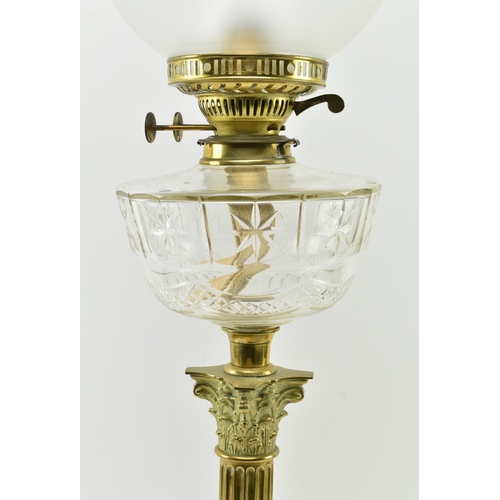 322 - A Victorian 19th century gilt metal & glass reservoir oil lamp / light. The lamp having a glass ... 