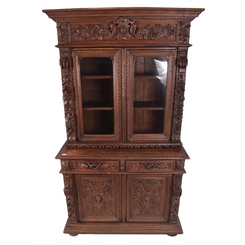 326 - A 19th century carved oak library bookcase cabinet. The bookcase having a twin door glazed top with ... 