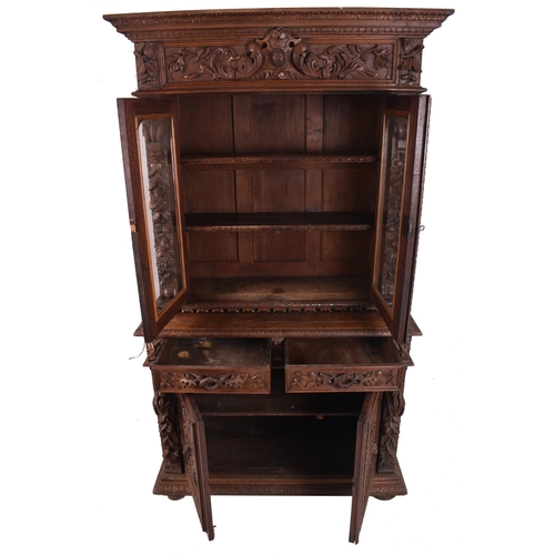 326 - A 19th century carved oak library bookcase cabinet. The bookcase having a twin door glazed top with ... 