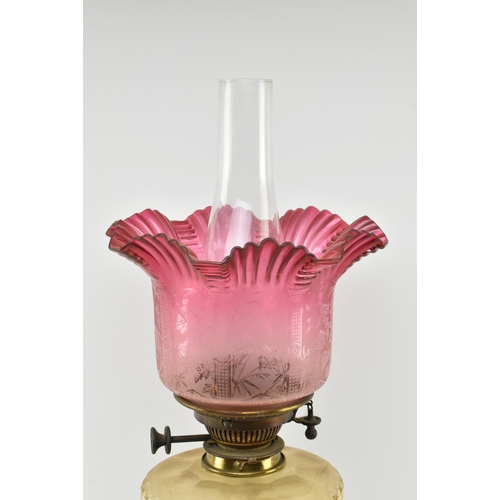 359 - A Victorian 19th century cranberry glass and gilt metal Corinthian column oil lamp. The lamp having ... 