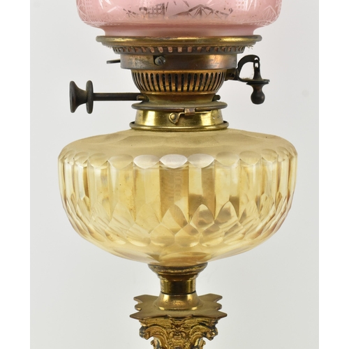 359 - A Victorian 19th century cranberry glass and gilt metal Corinthian column oil lamp. The lamp having ... 