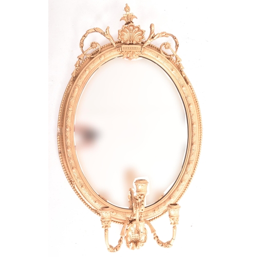 414 - A 19th century George III oval gilt wood and gesso worked girandole mirror. The mirror of rococo inf... 