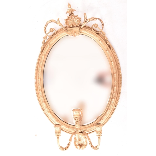 414 - A 19th century George III oval gilt wood and gesso worked girandole mirror. The mirror of rococo inf... 