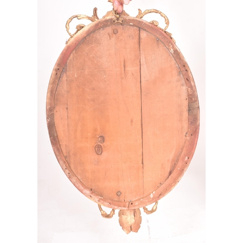 414 - A 19th century George III oval gilt wood and gesso worked girandole mirror. The mirror of rococo inf... 