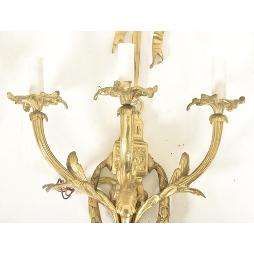 446 - A set of four French Louis XVI inspired gilt metal three arm decorative wall sconces lights. Each ha... 