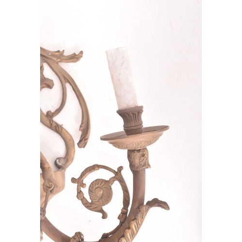 472 - A French Louis XVI style 20th century brass cherub wall sconce light. The sconce having a ram head s... 