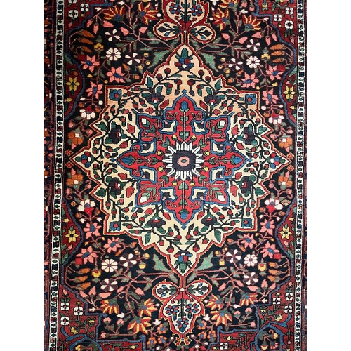 494 - An early 20th centuy Persian Islamic Bakhtiari hand woven floor carpet rug. The rug having a polychr... 