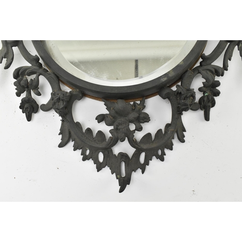 516 - A Victorian mid 19th century Gothic style cast iron wall mirror. The mirror with scrolled and foliat... 