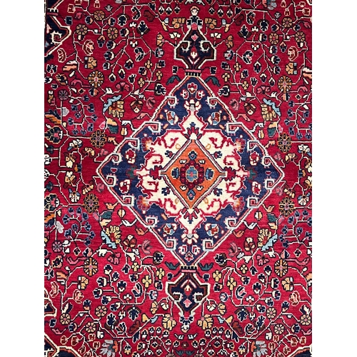 531 - A 20th century North West Persian Islamic Sarouk floor carpet rug. The rug having a diamond shaped c... 