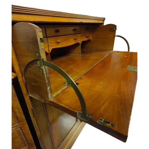 556 - An early 19th century Sheraton Revival mahogany secretaire bookcase. The bookcase having a flared pe... 