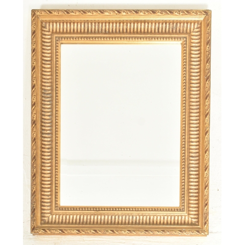 567 - A French Empire inspired 20th century gilt wood wall hanging mirror. The mirror having a carved twis... 