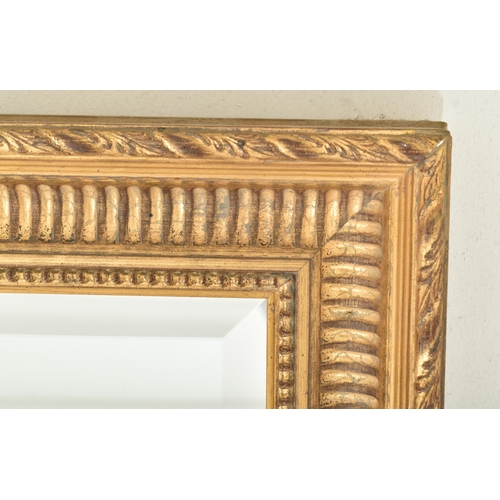 567 - A French Empire inspired 20th century gilt wood wall hanging mirror. The mirror having a carved twis... 