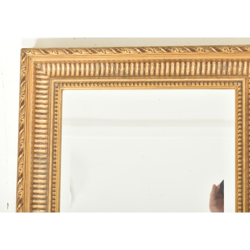 567 - A French Empire inspired 20th century gilt wood wall hanging mirror. The mirror having a carved twis... 