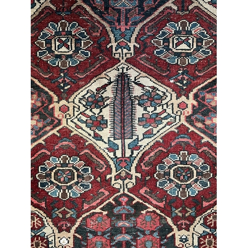 571 - An early 20th century Persian Islamic Bakhtiari hand woven floor carpet rug. The rug having a centra... 