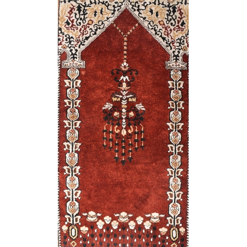 576 - A 20th century Persian qum silk prayer rug. Red and white, with central candle motif surrounded with... 