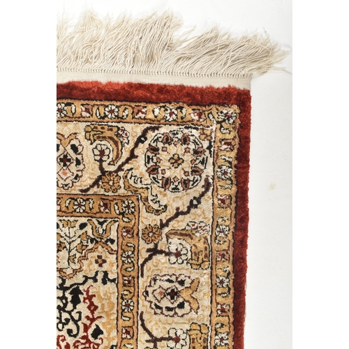 576 - A 20th century Persian qum silk prayer rug. Red and white, with central candle motif surrounded with... 