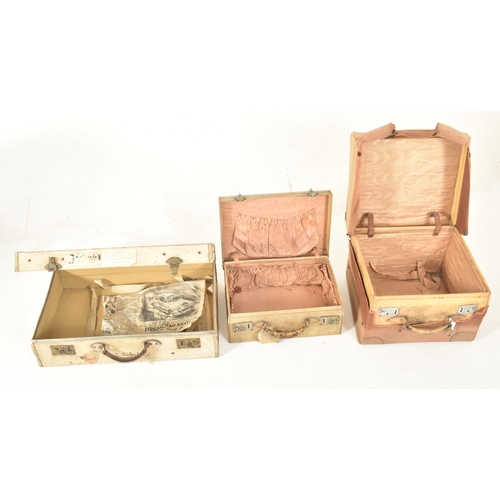 581 - A set of four early 20th century paper vellum style cream decorative travelling suitcases in varying... 