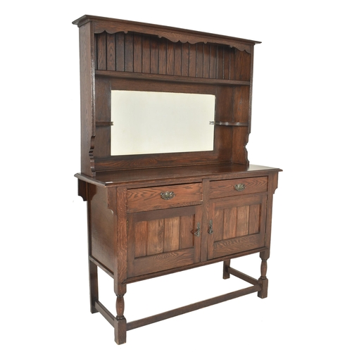 587 - G. Hardy & Co Ltd - a 20th century oak Welsh dresser with mirror. The dresser having a shaped ap... 