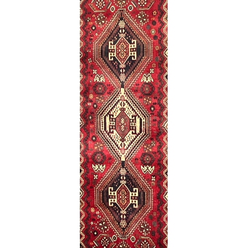 592 - A 20th century South West Persian Islamic Qashgai floor carpet runner rug. The rug having three cent... 