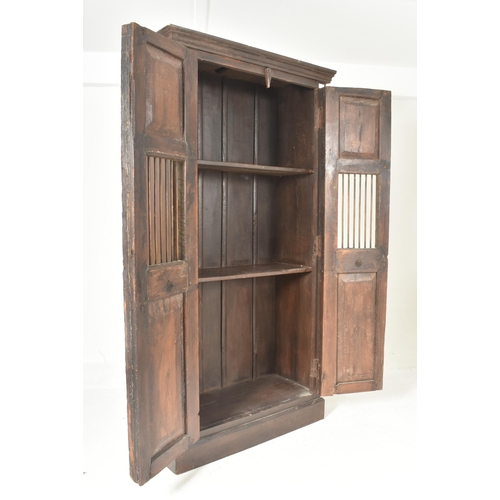 594 - A 19th century Indian stained teak housekeeper / kitchen cupboard. The cupboard having a two full le... 