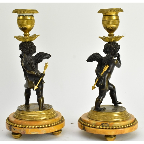 20 - A 19th century French Empire style mantle clock, along with two candlestick garnitures. The clock wi... 