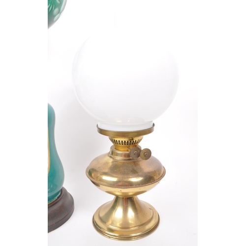 10 - A collection of three late 19th century oil lamps, one converted to electric. Featuring two brass bo... 