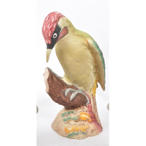 130 - A collection of eight 20th-century ornaments and figurines, comprising of a Beswick 1218 'Woodpecker... 