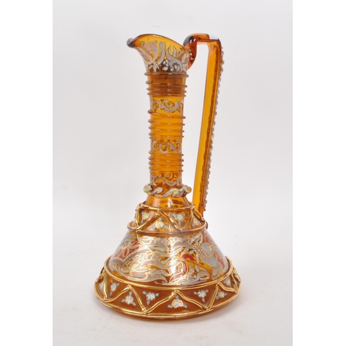 16 - A vintage 20th century amber glass ewer, with geometric and swirling gilt decoration, including hand... 