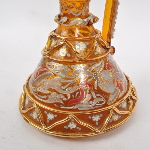 16 - A vintage 20th century amber glass ewer, with geometric and swirling gilt decoration, including hand... 