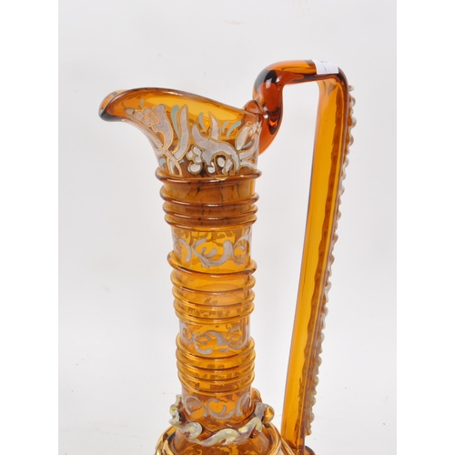 16 - A vintage 20th century amber glass ewer, with geometric and swirling gilt decoration, including hand... 