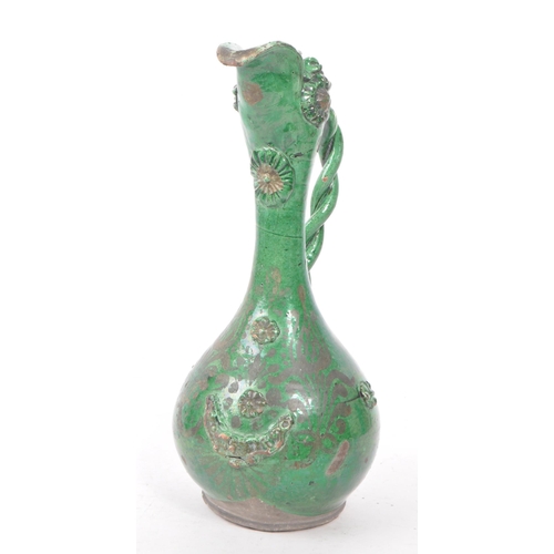 20 - A 19th century Turkish Ottoman canakkale pottery ewer, with a green glaze. Featuring a braided handl... 