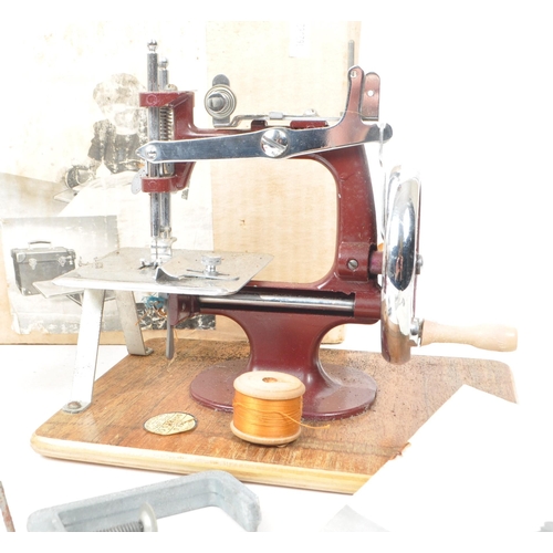 203 - Two vintage mid century child's sewing machine, comprising of a Vulcan senior model, in maroon and a... 