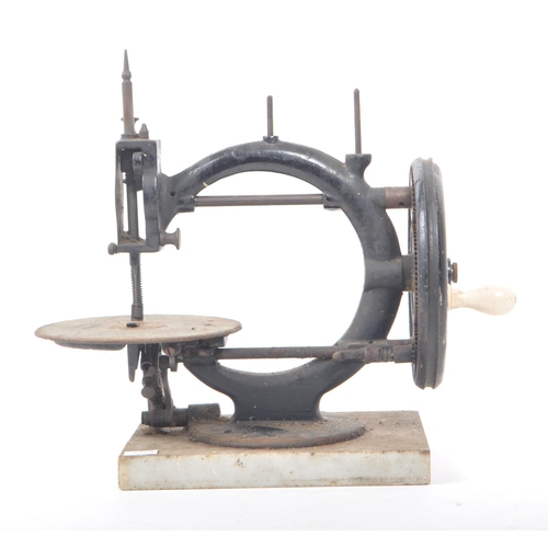 206 - A vintage 19th century cast iron sewing machine, with a marble base. Featuring a ceramic hand crank,... 