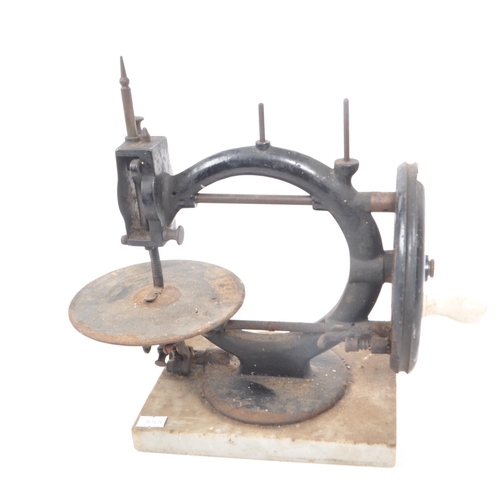 206 - A vintage 19th century cast iron sewing machine, with a marble base. Featuring a ceramic hand crank,... 