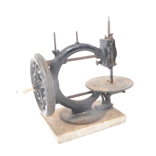 206 - A vintage 19th century cast iron sewing machine, with a marble base. Featuring a ceramic hand crank,... 