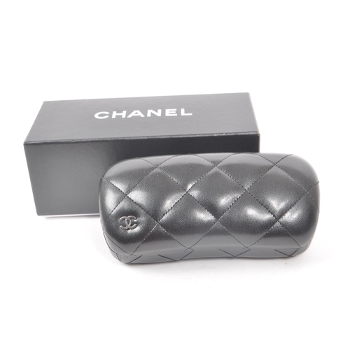 208 - A Chanel black glasses case, with the original box, drawstring bag and paperwork. Measuring approx. ... 