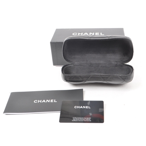 208 - A Chanel black glasses case, with the original box, drawstring bag and paperwork. Measuring approx. ... 