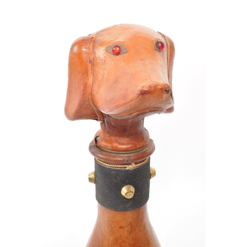 251 - A leather covered glass decanter with a rubber stopper, designed to look like a dog. Additional feat... 